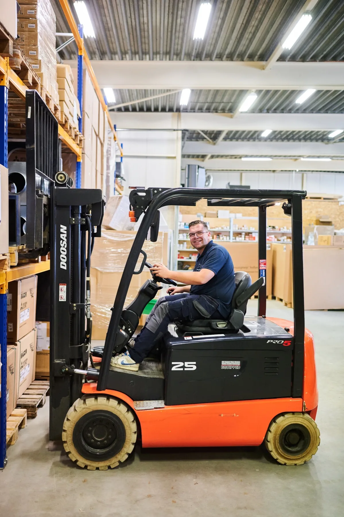 Collega op de heftruck in het magazijn