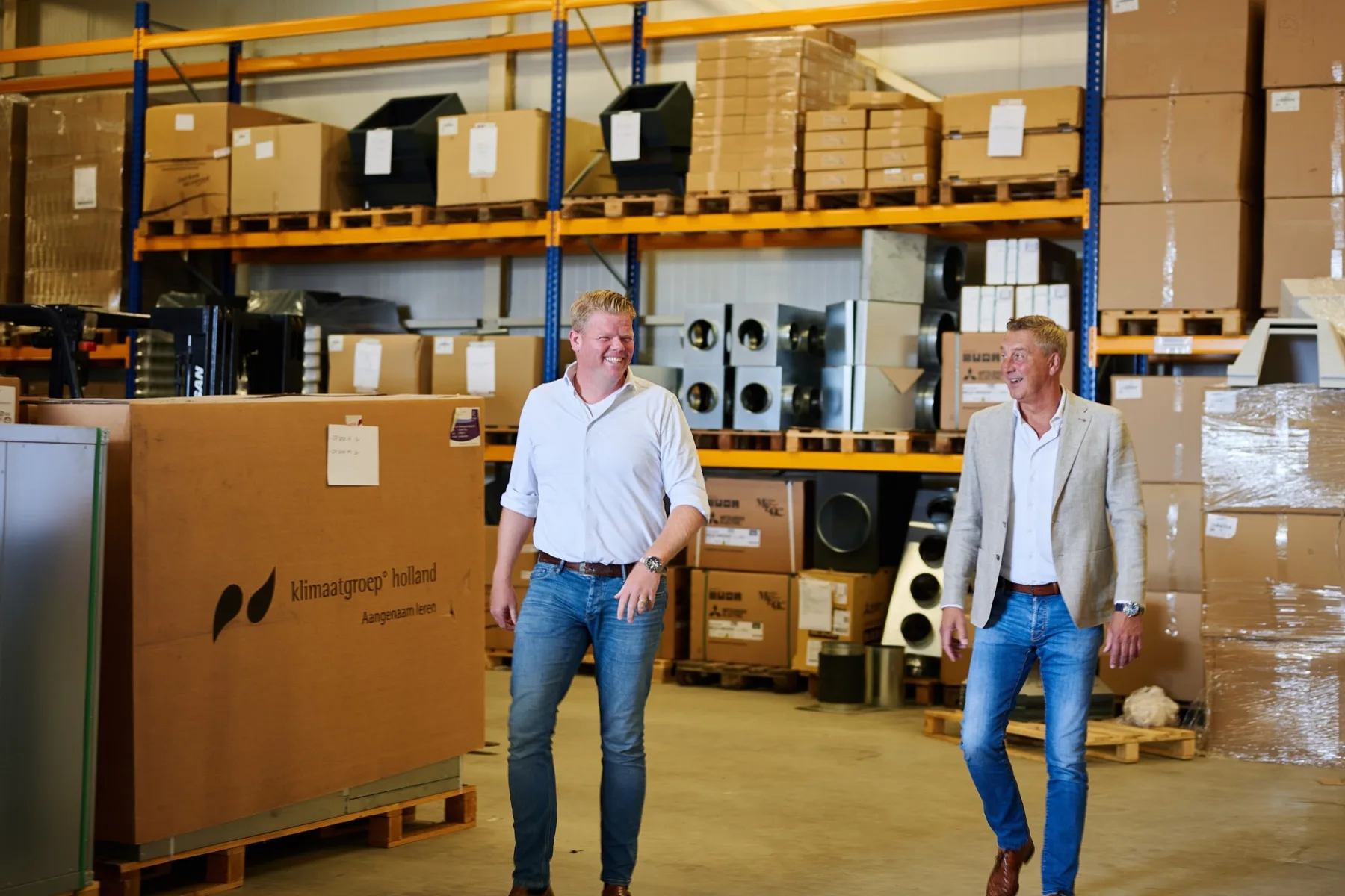 Twee collega's lopen door het magazijn van Klimaatgroep Holland in Groningen