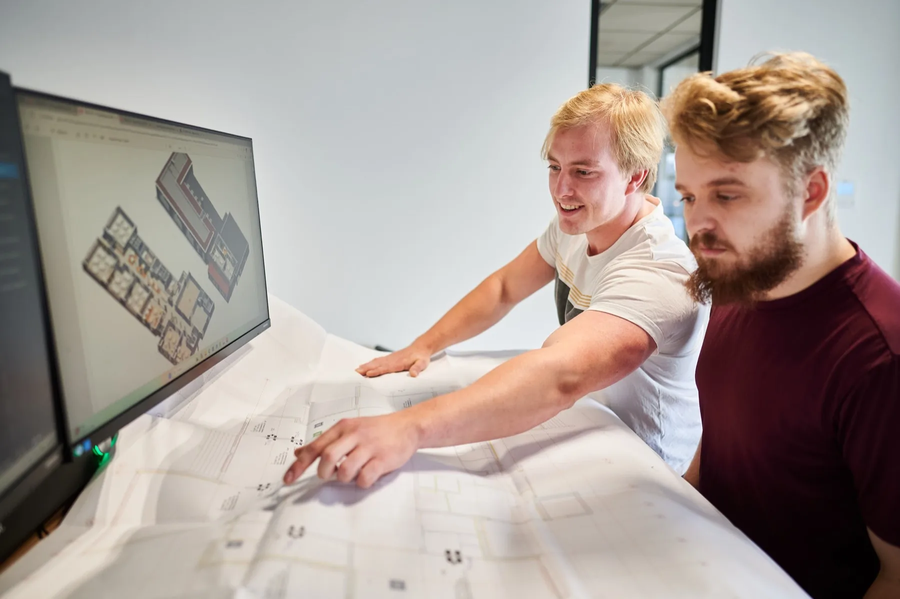 Twee werkvoorbereiders bij een tekening en een 3D-model